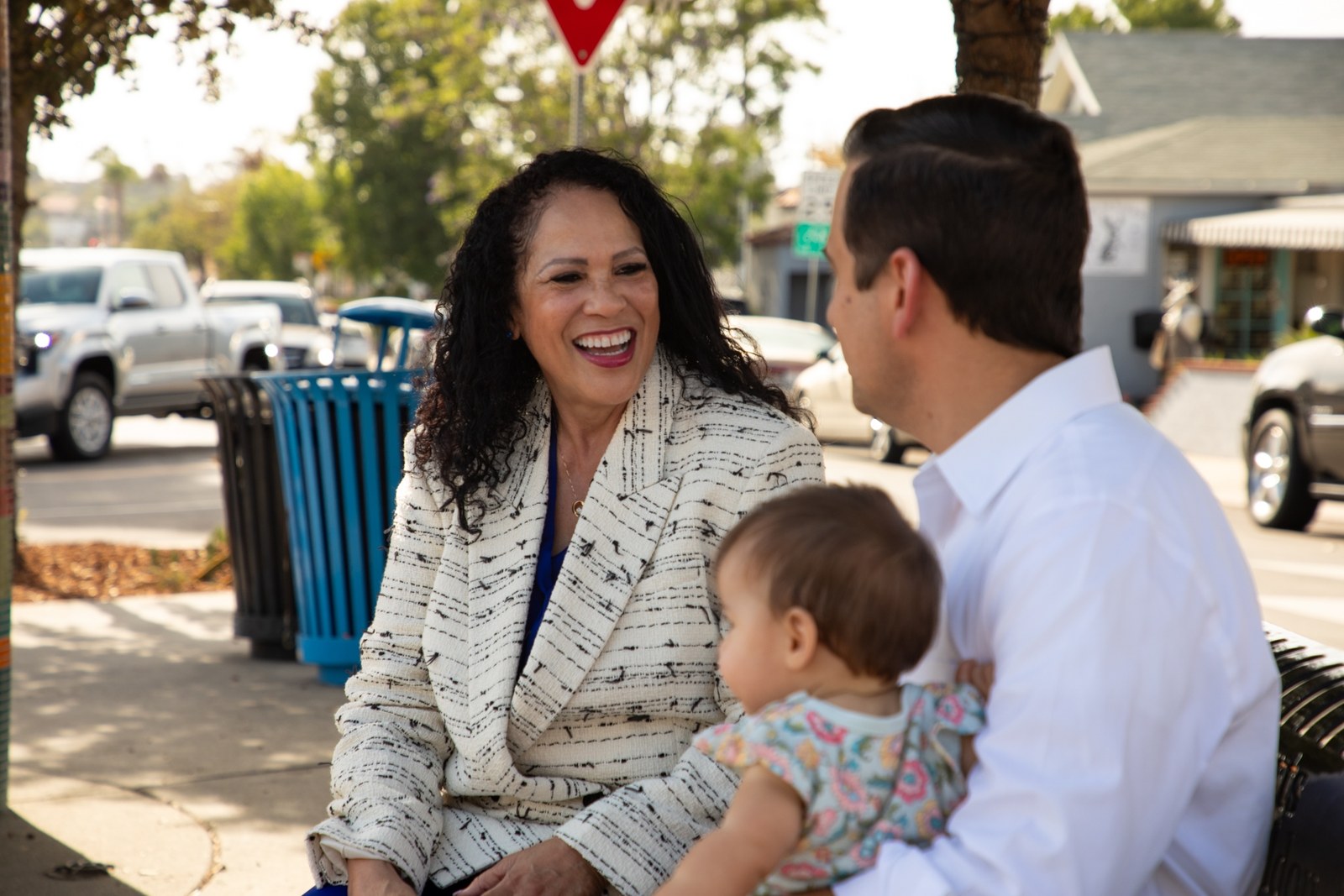 Patricia Dillard talking with a father and his baby on a La Mesa street